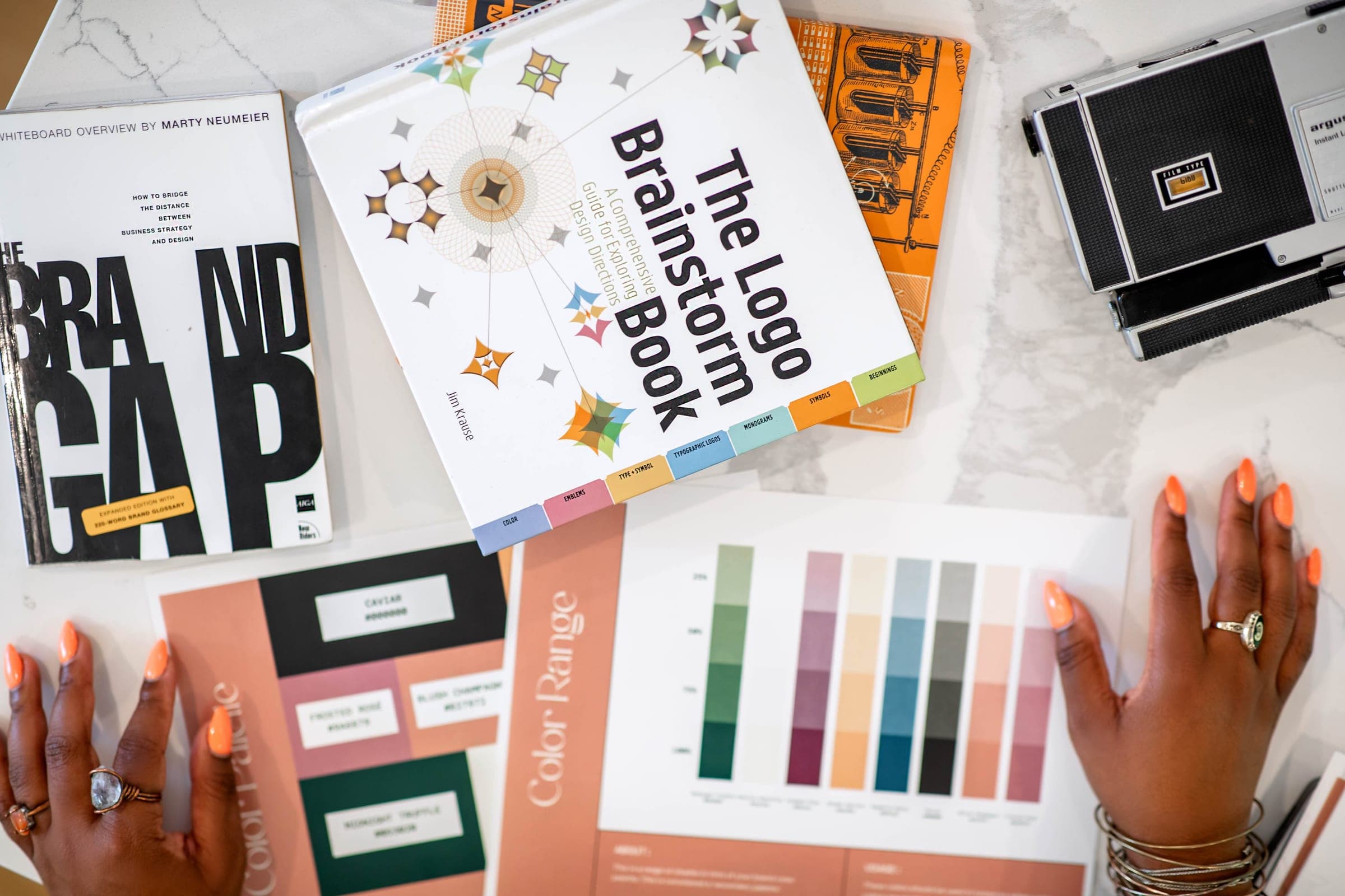 Rice & Gravy Studio brand strategy session — colour ranges, palettes and brand books laid out on a marble table